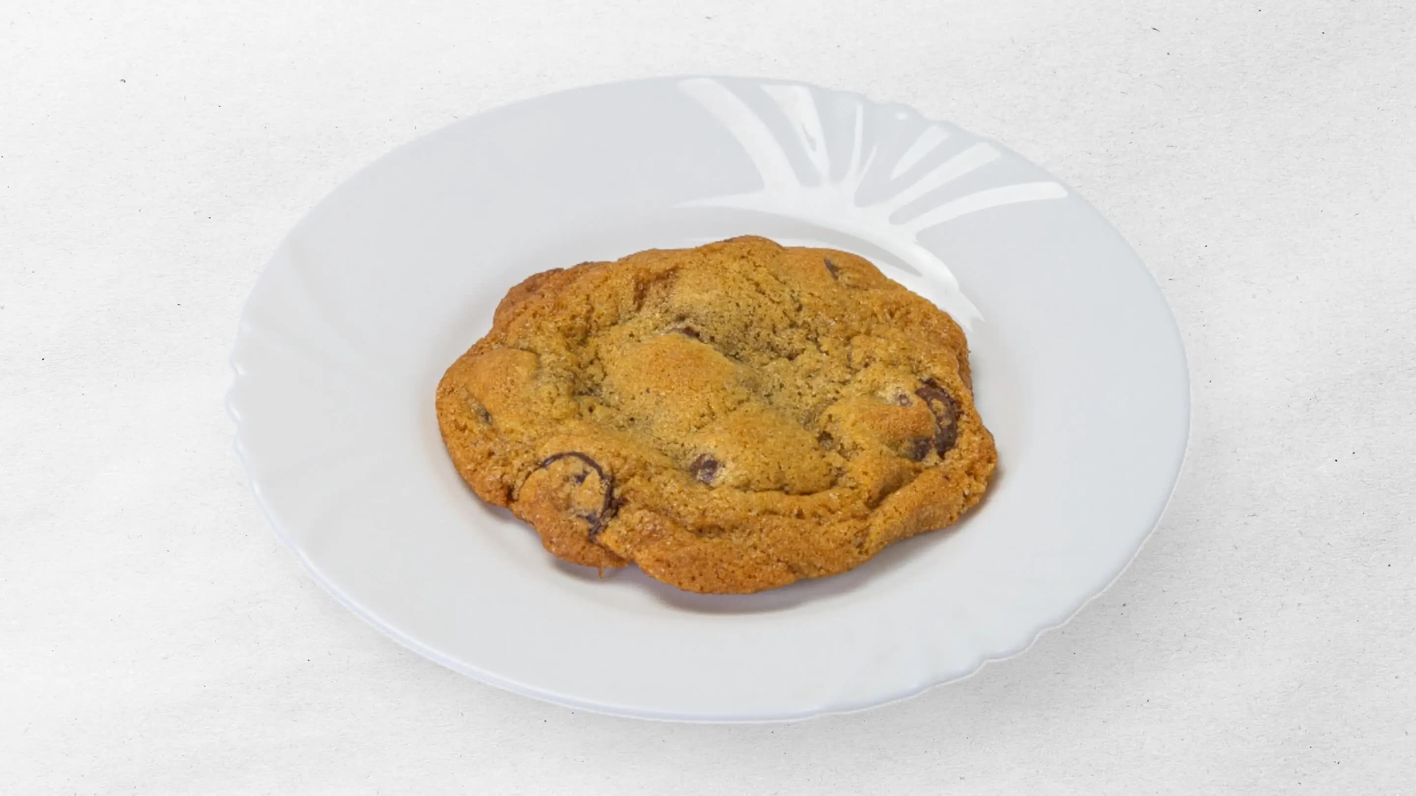 Chocolate chip cookie served on a white plate