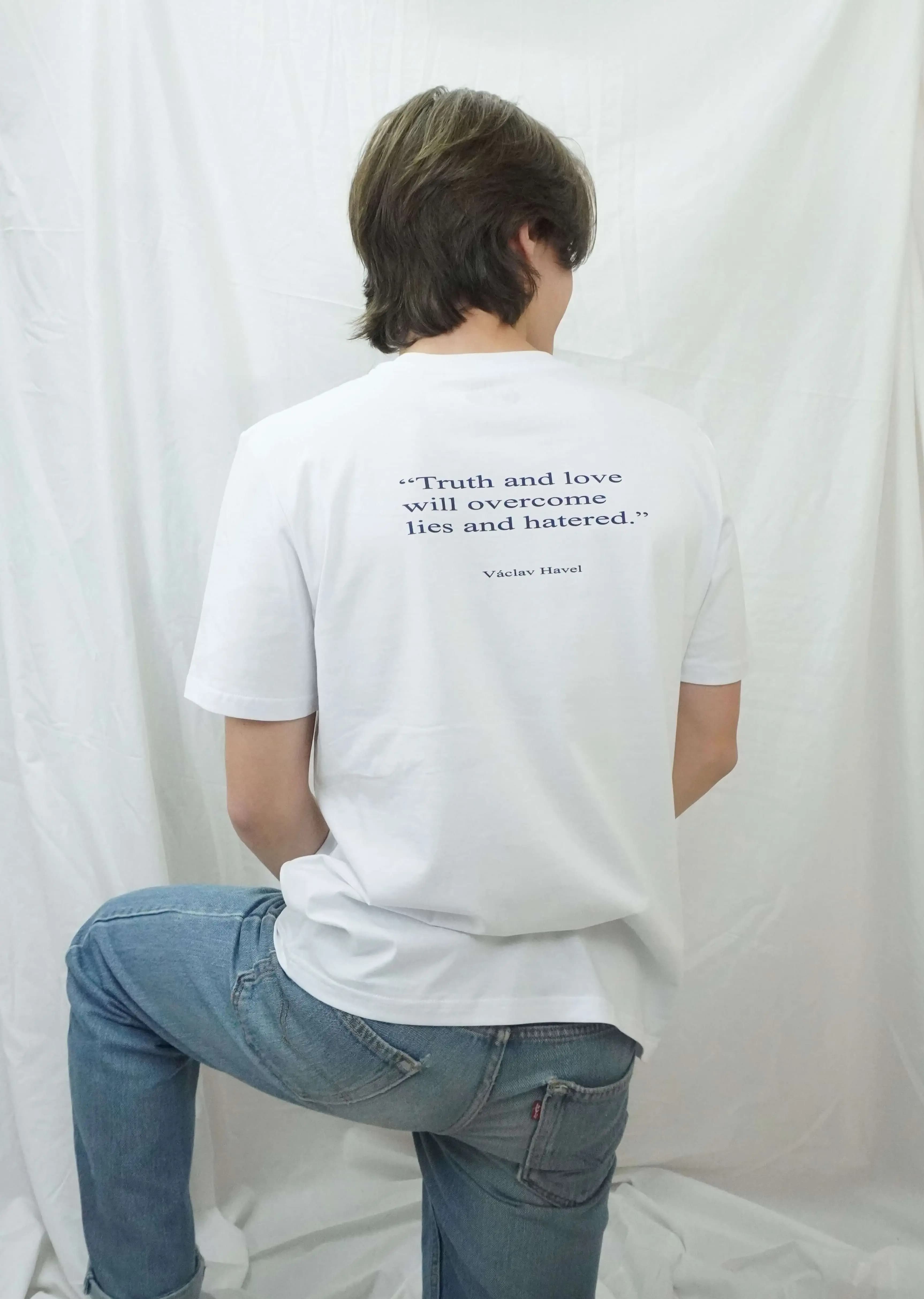 Rear view of a model wearing the white Václav Havel T-shirt with the quote “Truth and love will overcome lies and hatred.”
