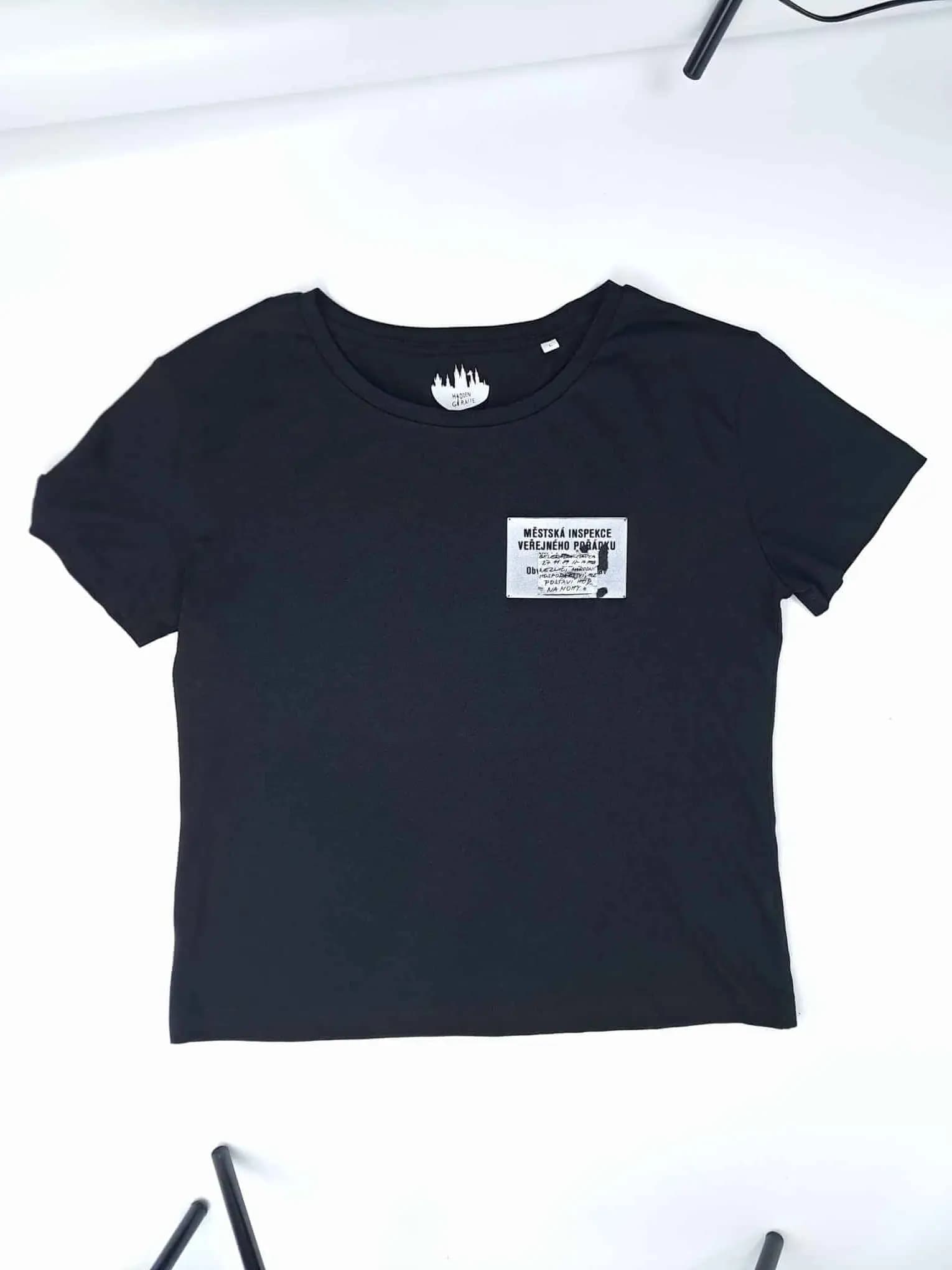 Black Hidden Giraffe T-shirt with a small “Městská inspekce veřejného pořádku” patch on the chest.