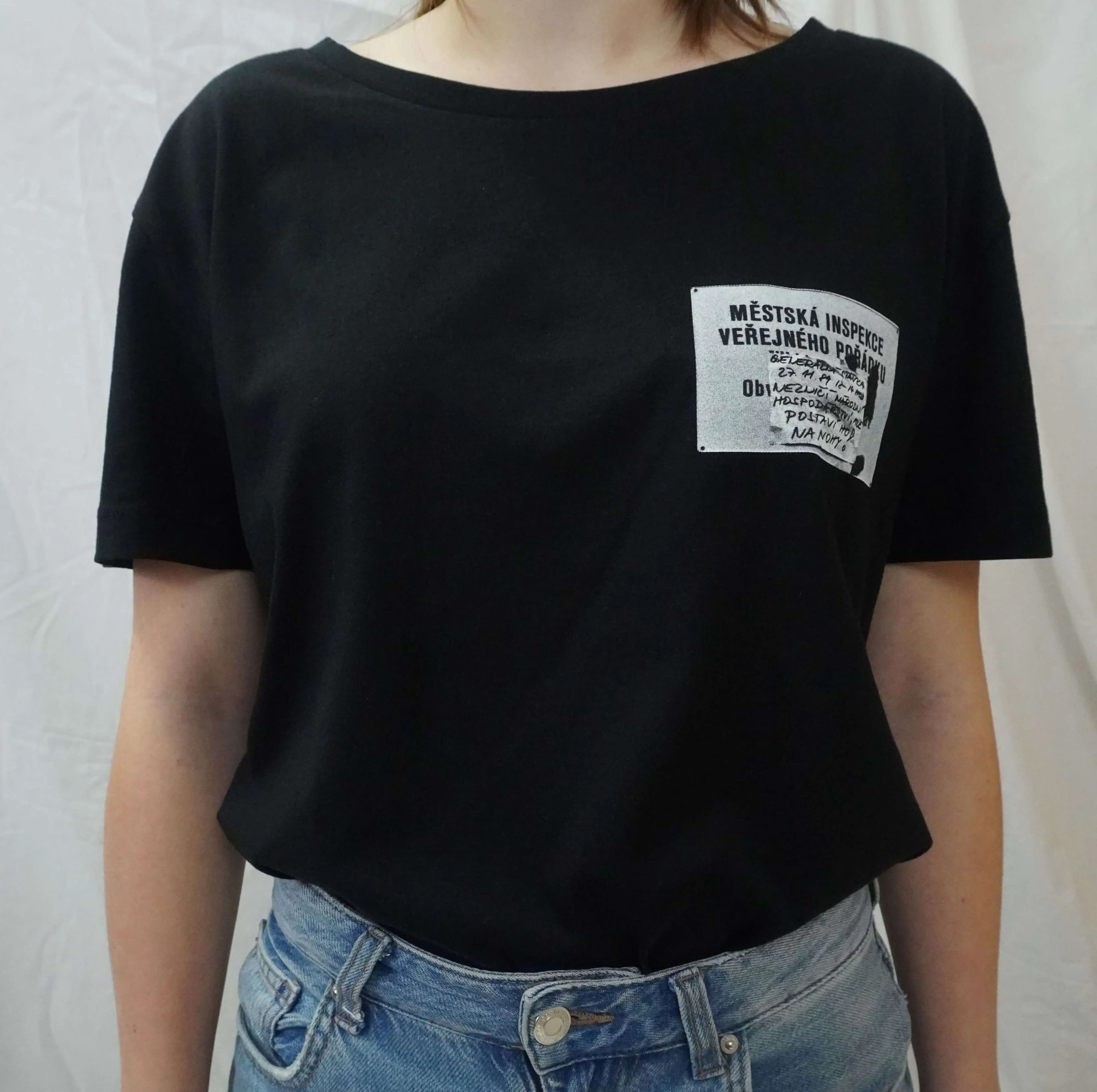 Front view of a model wearing a black T-shirt with a small Municipal Public Order Inspection print on the chest.