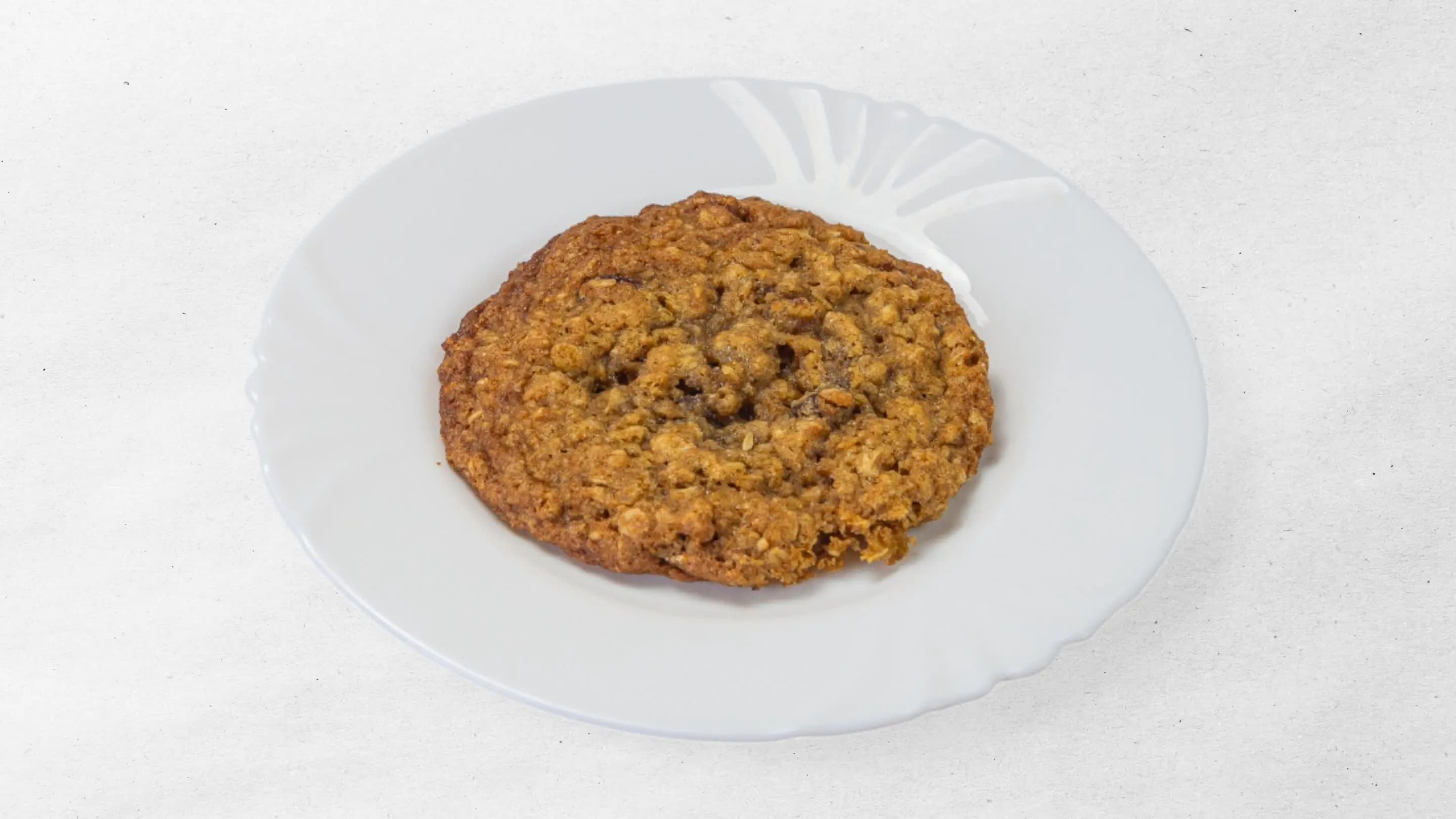 Oatmeal cookie with raisins served on a white plate